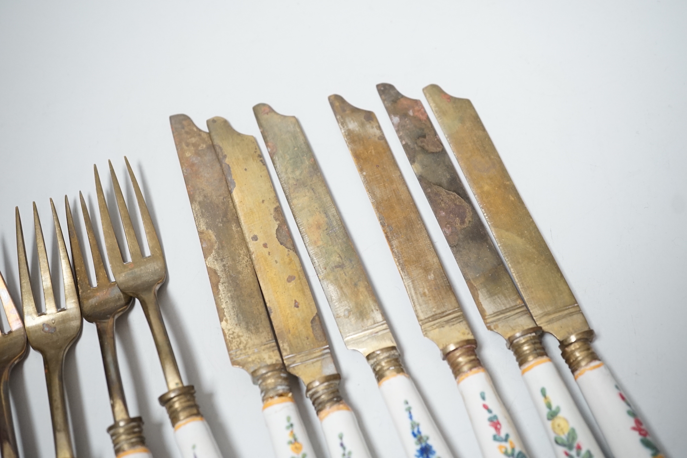 Six pairs of French Faience pistol grip handled knives and forks